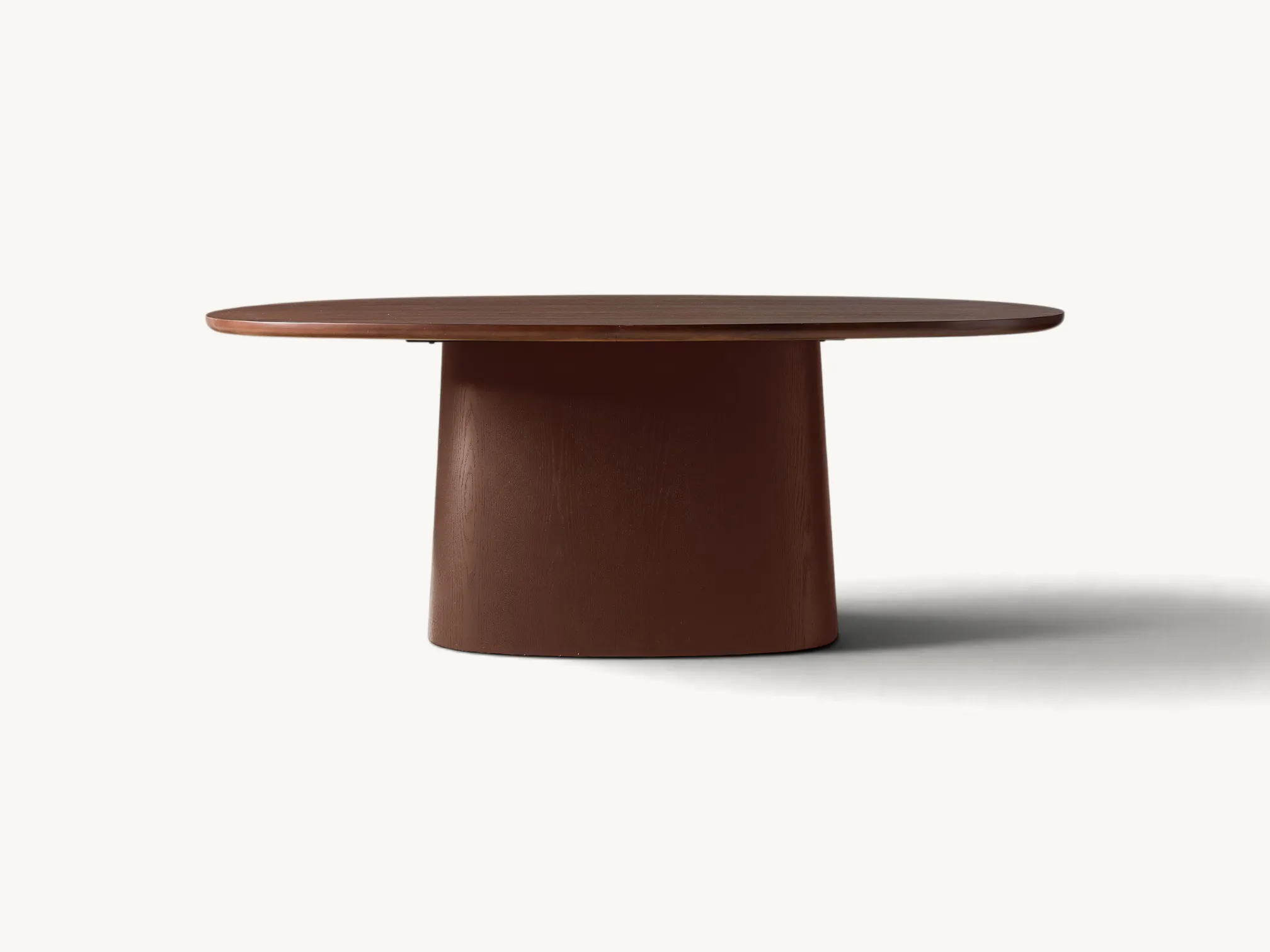 Oval wooden dining table with a thick central pedestal base in a rich warm brown wood finish