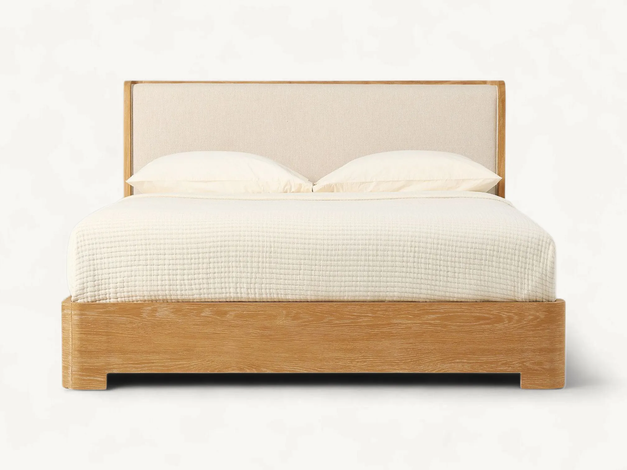 Modern teak wood bed frame with cream upholstered headboard and rounded corners.