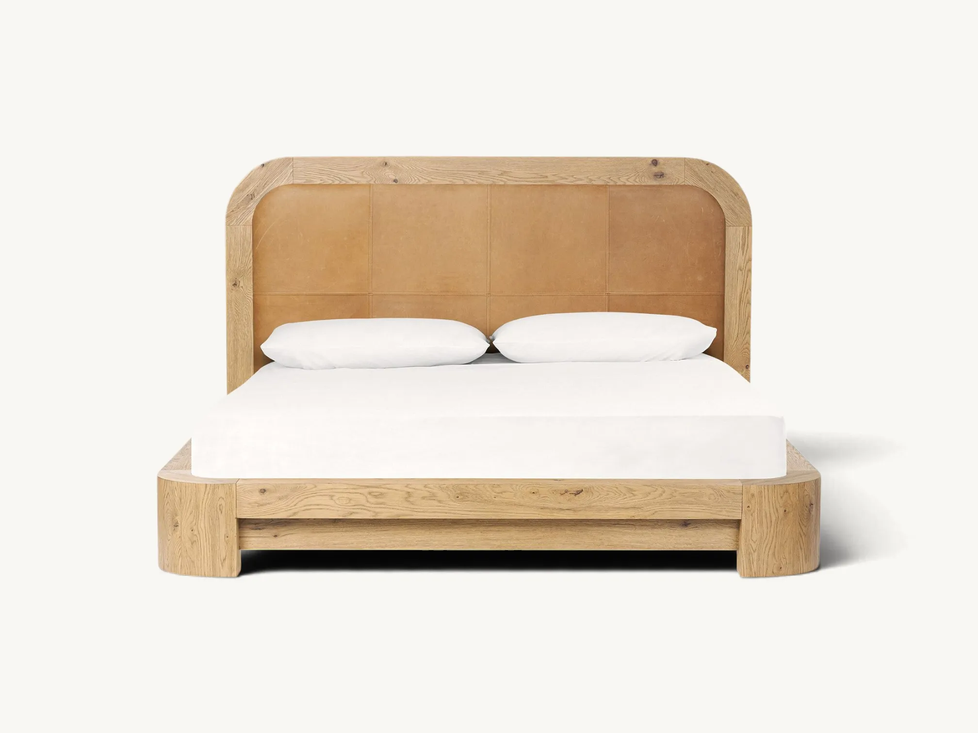 Solid oak wooden platform bed frame with thick rounded corner block legs and a tall curved-top headboard inset with stitched camel brown leather upholstery panels.