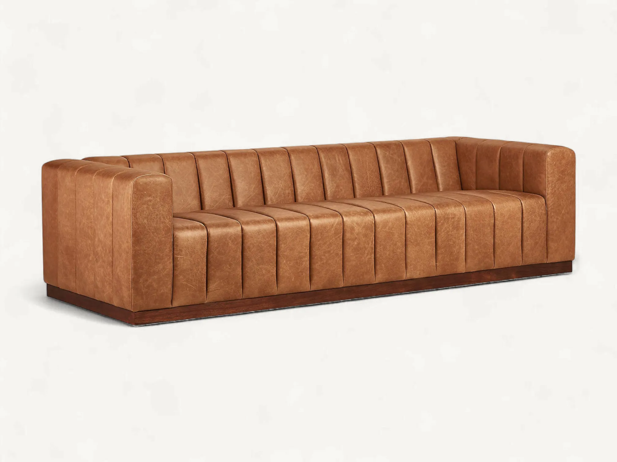 Tan leather channel-tufted sofa with a dark-stained solid teak wood base.