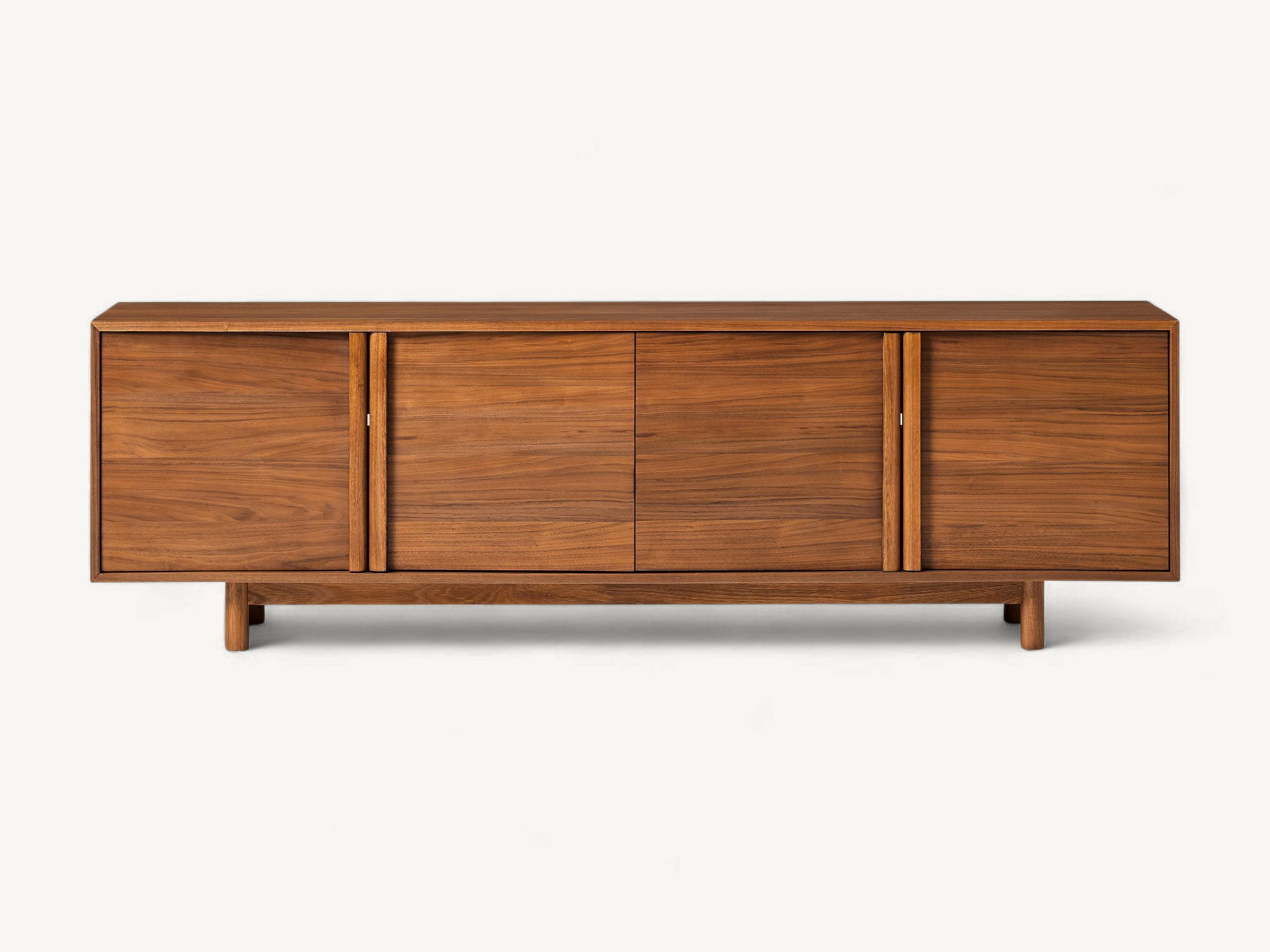 Minimalist natural teak wood media console with four cabinet doors, integrated wooden handles, and short round tapered legs.