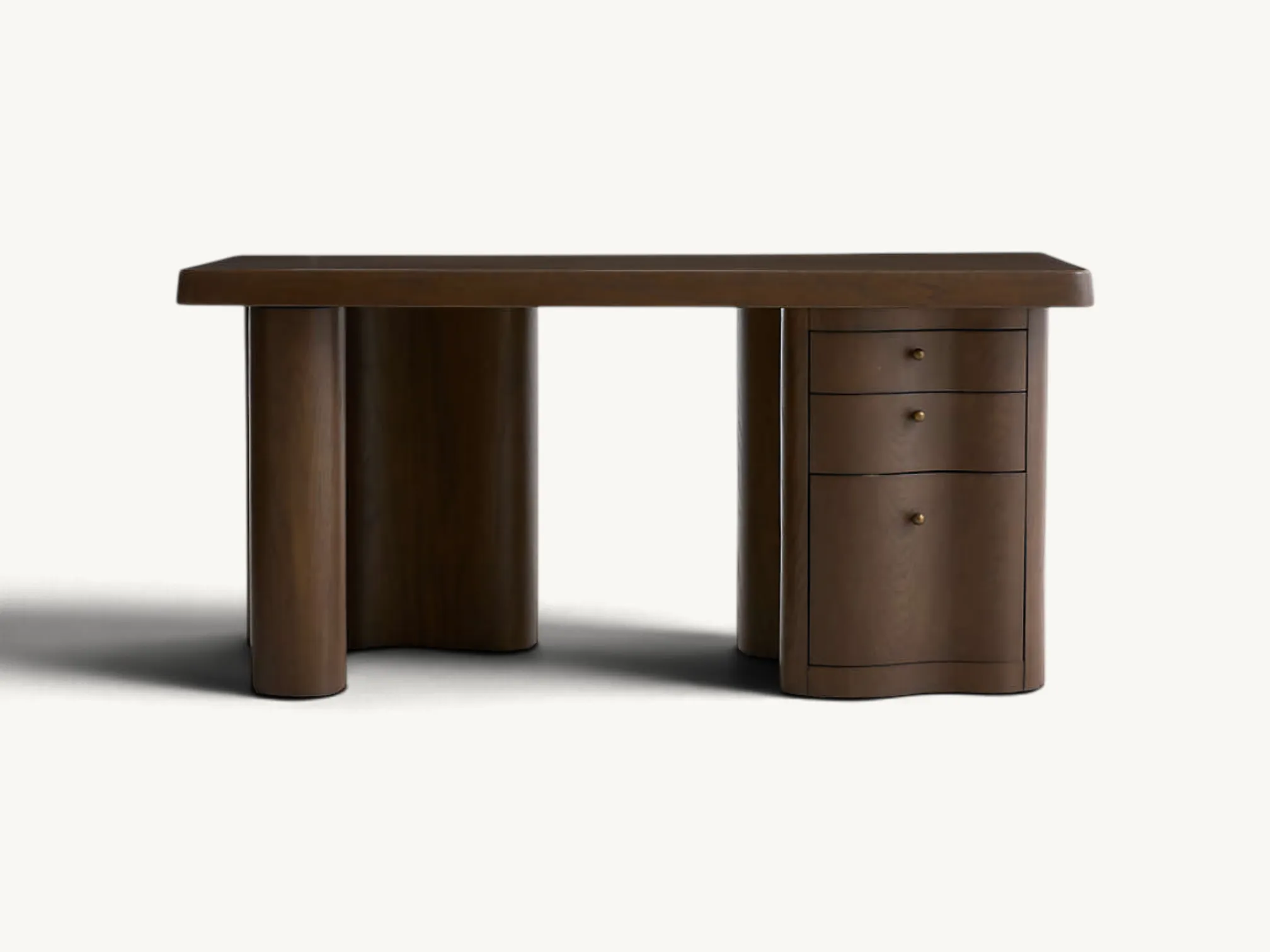 Dark walnut wooden desk featuring a thick tabletop with rounded corners, sculptured wavy pedestal legs, three integrated storage drawers, and small metallic brass knobs