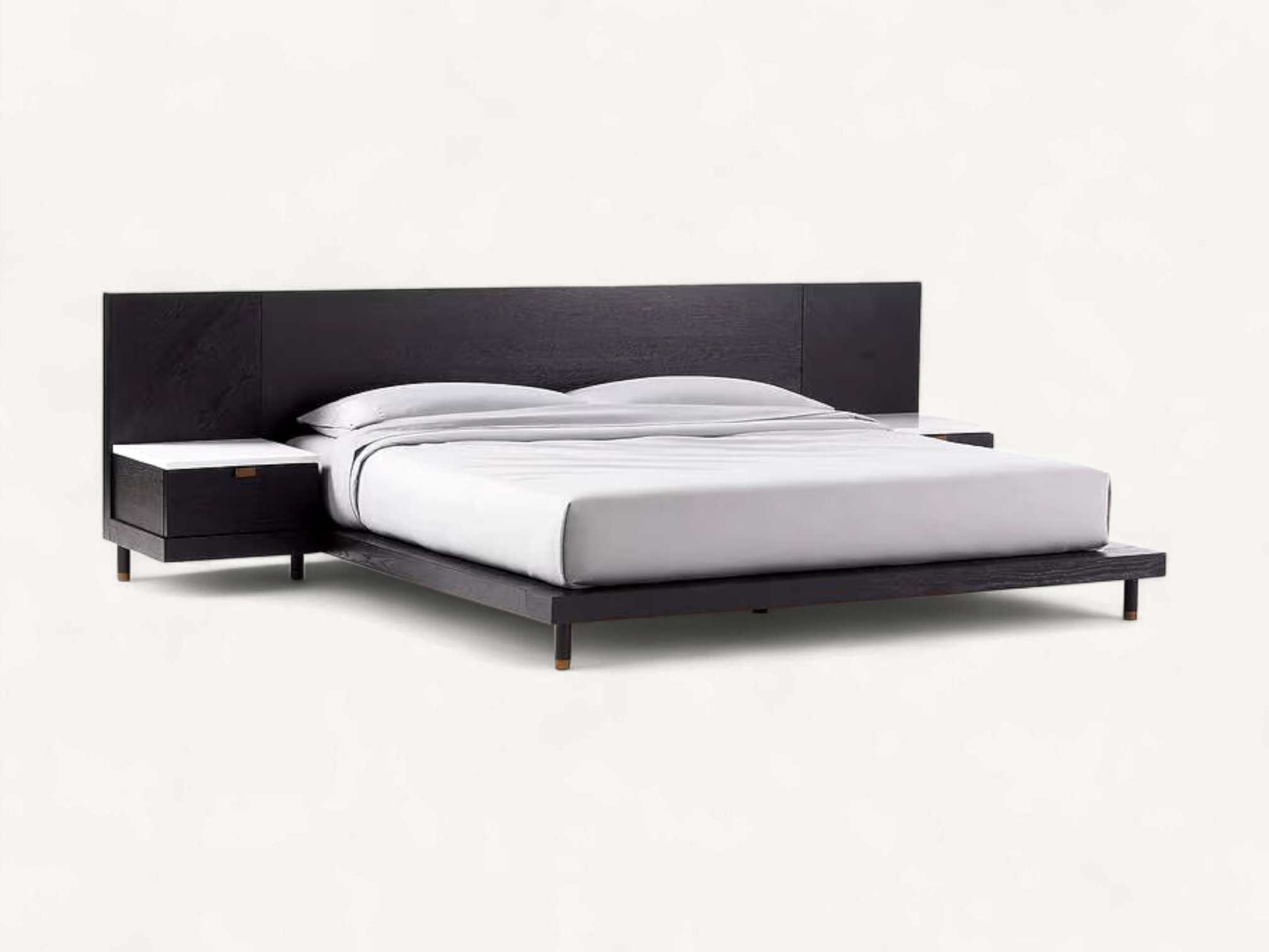 Low-profile black wooden modern platform bed with an extended wide headboard, integrated single-drawer floating nightstands featuring white marble tops, and slender cylindrical legs with brass feet.