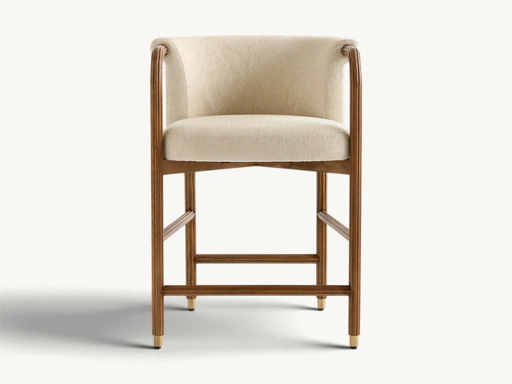 Upholstered counter stool with textured cream fabric barrel seat, fluted wooden frame, and brass-tipped legs