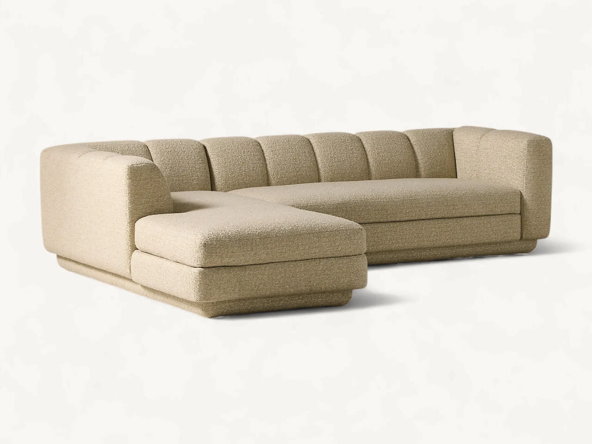 Modern L-shaped sectional sofa with channel tufted backrest and textured beige bouclé upholstery.